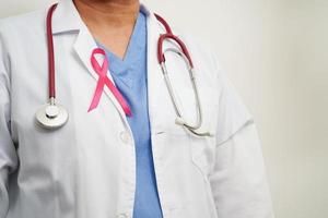 Aziatisch vrouw dokter met roze lint, wereld borst kanker dag Bij oktober. foto