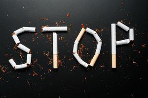 de opschrift hou op van sigaretten Aan een zwart achtergrond. hou op roken. de concept van roken doodt. motivatie opschrift naar stoppen roken, ongezond gewoonte. foto