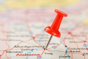 rood klerikaal naald- Aan een kaart van Verenigde Staten van Amerika, zuiden Alabama en de hoofdstad Montgomery. dichtbij omhoog kaart van zuiden Alabama met rood tack foto
