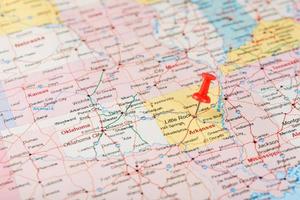 rood klerikaal naald- Aan een kaart van Verenigde Staten van Amerika, Arkansas en de hoofdstad weinig steen. dichtbij omhoog kaart van Arkansas met rood tack foto