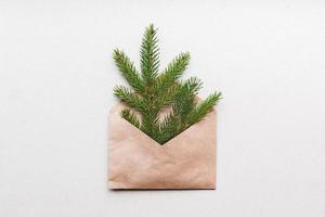 Kerstmis boom in bruin papier envelop Aan gerecycled karton achtergrond, plastic vrij eco neiging vakantie cadeaus foto