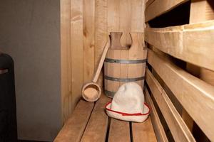 traditioneel oud russisch badhuis spa concept. interieur details Finse sauna stoomcabine met traditionele sauna accessoires set schepvilt. ontspannen land dorp bad concept. foto