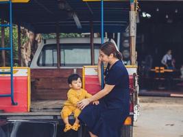 Aziatisch moeder en zoon van Thais nationaliteit en oud auto Bij de mala cafe, thung salie, sukhothai, Thailand. foto