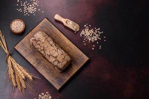 een brood van bruin brood met granen van granen Aan een houten snijdend bord foto