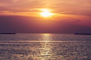 kalme zee met zonsonderganghemel, prachtig panoramisch uitzicht, verbazingwekkende dramatische rijzende zon weerspiegeld in water foto