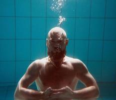 atletisch sport Mens onderwater- in de zwemmen zwembad. sport, yoga, vrij duiken concept foto