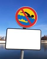 de teken verbieden zwemmen in de bevaarbaar rivier- met blanco wit plaque voor tekst. winter zonnig dag, blauw lucht. foto