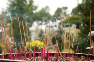 aroma stokjes in de buurt naar de tempel Aan een achtergrond van tuin met geel bloemen. tint, Vietnam. foto