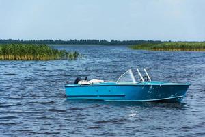 aluminium blauw visvangst boot met een motor in de buurt de meer oever, vissen, actief recreatie, achtergrond van natuur. foto