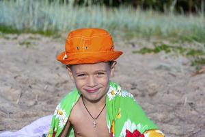 een jongen Aan de strand in Panama en met een handdoek, doekjes zichzelf van zee water na zwemmen in de zee foto