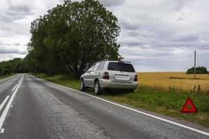 een auto aan het wachten voor reparatie na een afbreken, een gebroken auto Aan de kant van de weg, een noodgeval hou op teken foto