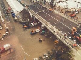 bouw van een nieuw brug in de stad centrum, visie van bovenstaande. bouw machinerie is werken Aan houdende nieuw asfalt. markering en bestrating foto