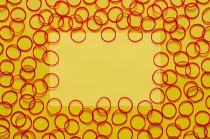 rood kleur elastisch rubber bands zetten Aan geel achtergrond met leeg ruimte voor achtergrond en abstract concept. foto