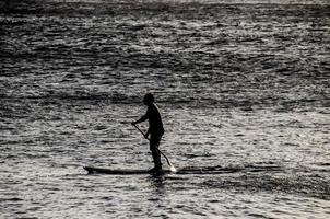 silhouet van een Mens in peddelen bord foto