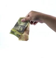 gorontalo-indonesië, november 2022 - hand- Holding Indonesisch geld geïsoleerd Aan wit achtergrond foto