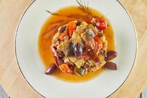 ratatouille ragoût met courgette, courgette, aubergine, paprika's en kers tomaten. versierd met olijven. Frans fijnproever keuken foto