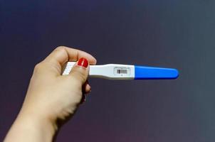 close-up van de hand met zwangerschapstest foto