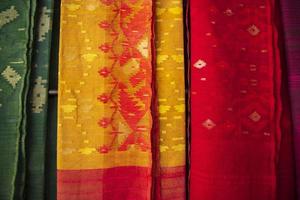 bangladesh vrouwen, s traditioneel kleurrijk jamdani Saree hangende in de kleinhandel showrooms. kleurrijk jamdani Saree structuur achtergrond foto