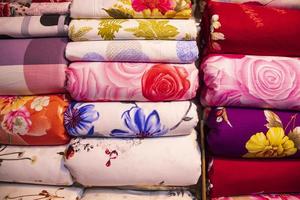 artistiek verscheidenheid schaduw toon kleuren bed lakens gestapeld Aan kleinhandel winkel plank naar uitverkoop foto