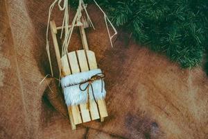 klein houten slee decoratie in voorkant van een houten muur voor Kerstmis foto