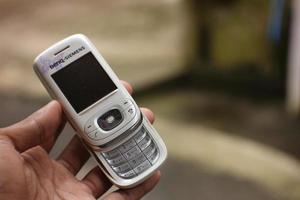 magelang, Indonesië, 2022-hand Holding een oude wit cel telefoon niet nog een android versie. foto