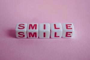 glimlach woord Aan de roze achtergrond, gevoelens en emoties foto