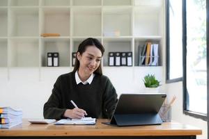 portret van een Aziatische jonge zakelijke vrouw werkt op een laptopcomputer in haar werkstation.business mensen werknemer freelance online rapport marketing e-commerce telemarketing concept. foto