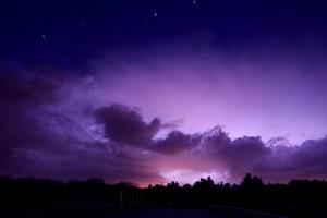 bliksem stakingen door storm wolken verhelderend de nacht lucht. foto