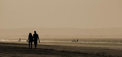 paar wandelen op een strand foto