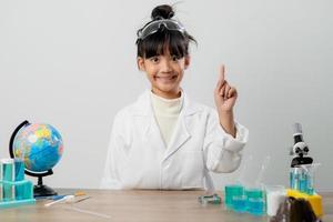 opleiding, wetenschap, chemie en kinderen concept - kinderen of studenten met test buis maken experiment Bij school- laboratorium foto