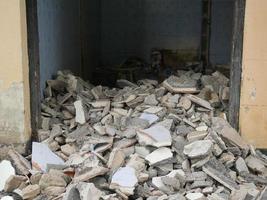 close-up van het puin van een industrieel gebouw dat instort in een stapel beton en baksteen. en het grillige puin veroorzaakt door het falen van de ingenieurs bij de verlaten constructie. foto