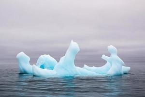 een blauw ijsberg drijvend in de zee in svalberg foto