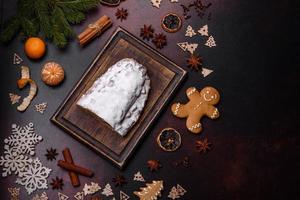 Kerstmis taart stollen met marsepein, bessen en noten Aan een donker beton achtergrond foto