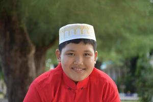 portret jong zuidoosten Aziatisch Islamitisch of moslim jongen in wit overhemd en hoed, geïsoleerd Aan wit, zacht en selectief focus. foto