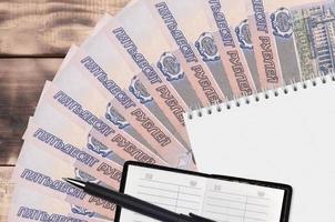 50 Russisch roebel rekeningen ventilator en kladblok met contact boek en zwart pen. concept van financieel planning en bedrijf strategie foto