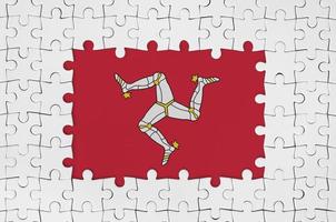 eiland van Mens vlag in kader van wit puzzel stukken met missend centraal een deel foto