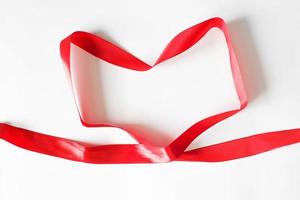 inpakken lint in de vorm van een rood hart, top visie Aan een wit achtergrond foto