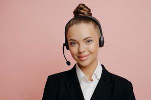 mooie zakenvrouw in headset die blij en tevreden is na online vergadering foto