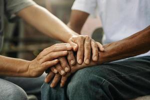 handen van de oud Mens en een vrouw hand- Aan de hout tafel foto