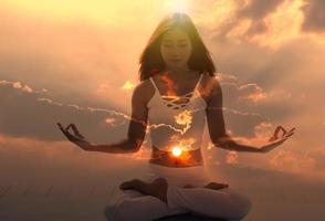 jong geestelijk meditatie aura vrouw met haar ogen Gesloten gevoel vrij Aan natuur energie Bij zonsopkomst. foto