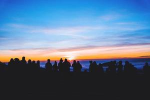 mensen reizen natuur. reizen kom tot rust. achtergrond silhouet mensen aan het kijken zonsopkomst en fotograferen foto