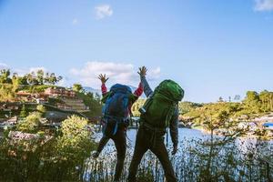 minnaar vrouwen en mannen aziaten reizen ontspannen in de vakantie. sta op zoek landschap op de bergen. blij met ontspannend toerisme. foto