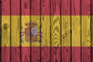 Spanje vlag afgebeeld in helder verf kleuren Aan oud houten muur. getextureerde banier Aan ruw achtergrond foto