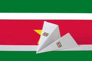 Suriname vlag afgebeeld Aan papier origami vliegtuig. handgemaakt kunsten concept foto