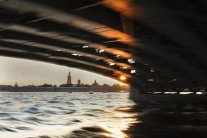 de silhouet van de peter en paul vesting Bij zonsondergang, visie van de Neva rivier- van onder de brug. lang Luik snelheid, uit van focus foto