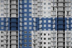 Finland vlag afgebeeld in verf kleuren Aan meerdere verdiepingen woonachtig gebouw onder bouw. getextureerde banier Aan steen muur achtergrond foto