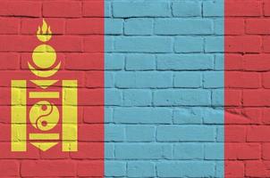 Mongolië vlag afgebeeld in verf kleuren Aan oud steen muur. getextureerde banier Aan groot steen muur metselwerk achtergrond foto