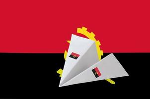 Angola vlag afgebeeld Aan papier origami vliegtuig. handgemaakt kunsten concept foto