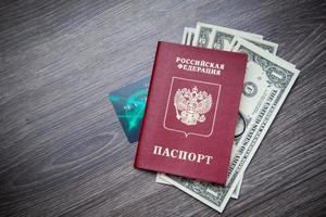 een buitenlands paspoort en dollars op een houten achtergrond. foto