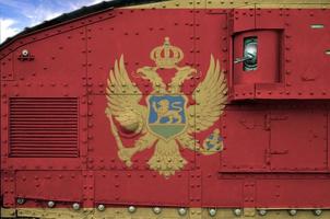 Montenegro vlag afgebeeld Aan kant een deel van leger gepantserd tank detailopname. leger krachten conceptuele achtergrond foto